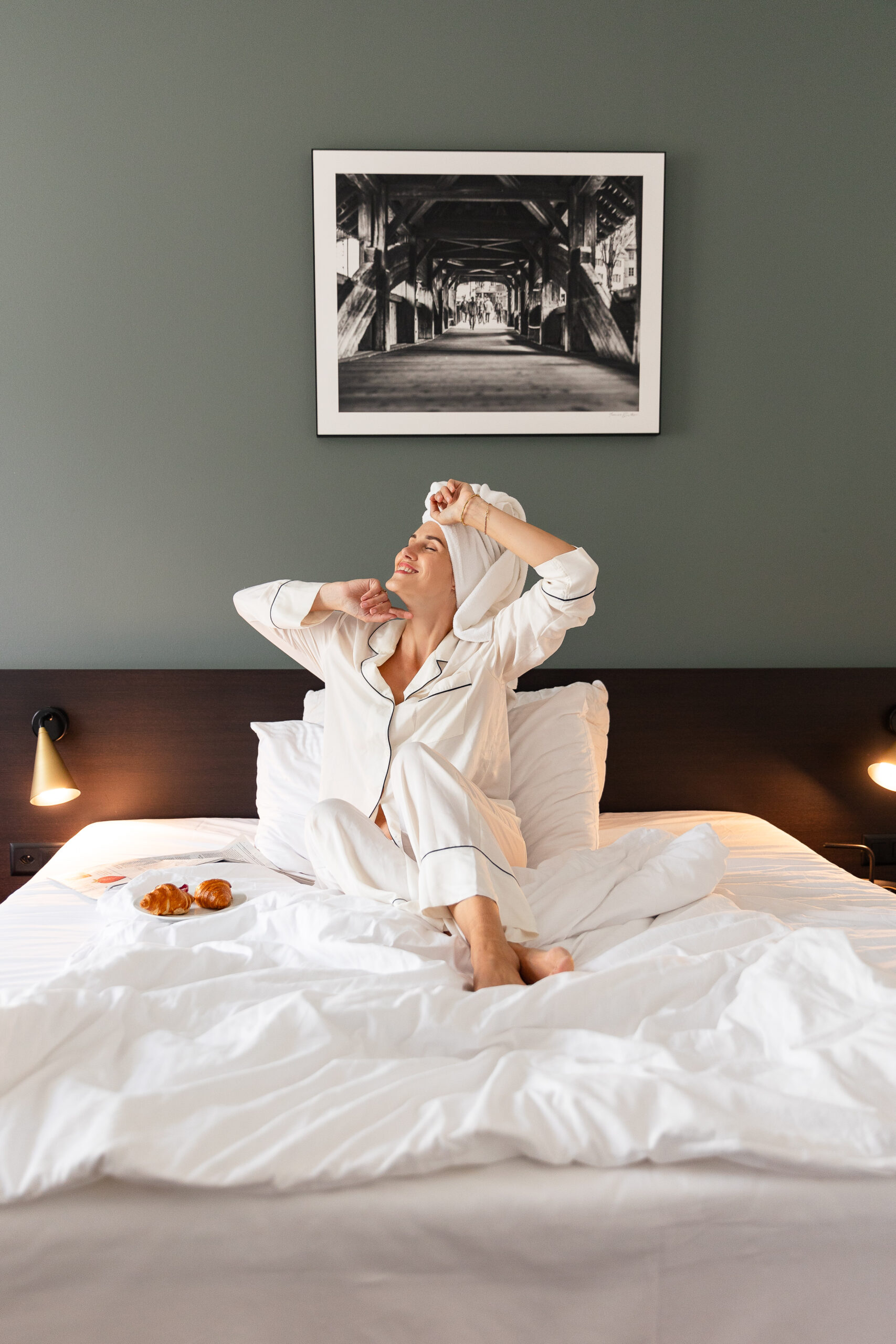 Hotelgast Frau wacht im Hotelzimmer vom Hotel Waldstätterhof Luzern auf im Bademantel